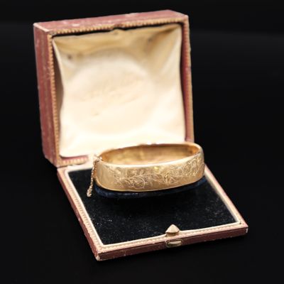 une bague en or dans une boîte posée sur une surface noire