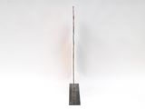 an image of a sculpture of a pole with a long stick sticking out of it ' s side