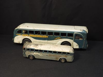 two toy buses sitting next to each other on a black surface