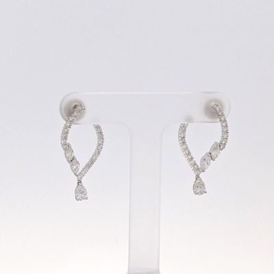 une paire de boucles d'oreilles en diamant posée sur un présentoir, sur fond blanc