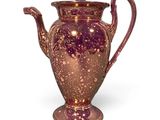un vase violet posé sur une surface blanche