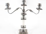 a silver plated candelab with three candles on a stand