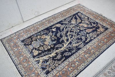 une image représentant un tapis bleu orné d'un motif représentant l'arbre de vie