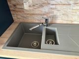 a kitchen sink with two faucets and a soap dispenser