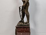 statue of a man standing on top of a wooden box