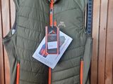 un gilet vert avec des fermetures éclair orange suspendu à un porte-vêtements