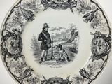 a black and white plate with a picture of a man and a dog