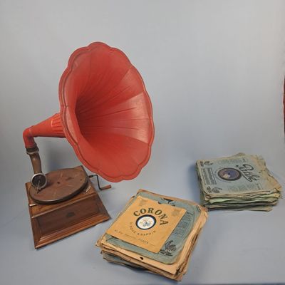 un gramophone rouge et une pile de livres à côté d'une pile de billets