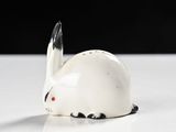 a small white rabbit figurine sitting on a table