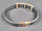 a close up of a metal bracelet with two cubes on it