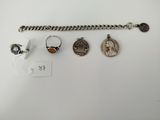 a collection of silver jewelry including a bracelet, ring, and a coin