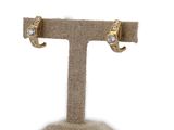 pair of earrings on a stand with a burlock cloth background