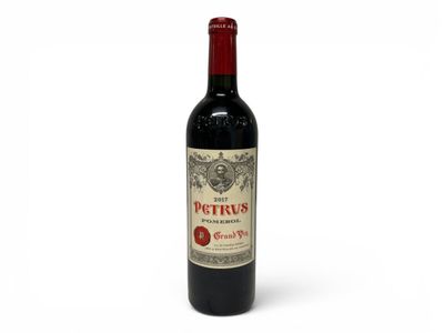 a bottle of red wine sitting on top of a white table