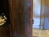 a cat that is sitting inside of a wooden cabinet