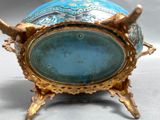 a blue and gold vase sitting on top of a stand