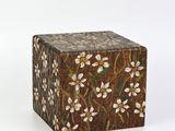 boîte marron et blanche ornée de fleurs blanches sur fond blanc