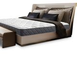 a bed with a mattress and a foot rest on it