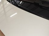 rear view of a white car with the hood open