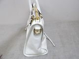 a white purse that is sitting on the floor