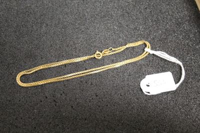 a gold chain and a white tag on a table