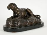 une image représentant une statue en bronze d'un lion posé sur un rocher