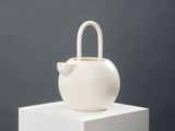 a white vase with a bow on top of it
