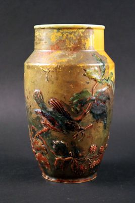 un vase jaune orné d'un oiseau sur fond noir