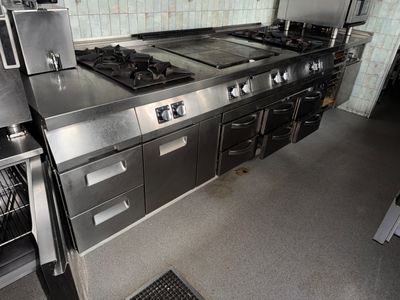 une cuisine équipée d'une cuisinière, d'un four et d'un lave-vaisselle