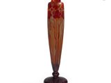un vase orange posé sur un socle en bois