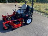 une photo d'une tondeuse autoportée rouge garée sur un parking