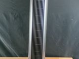 un ventilateur sur pied argenté posé sur une table en bois