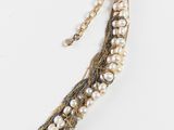 a close up of a necklace on a white surface