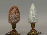 two vases that have shells on them on a table