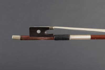 a close up of a violin bow with a piece of wood sticking out of it