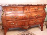 a wooden chest of drawers with a marble top