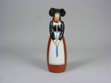 une figurine représentant une femme vêtue d'une robe et tenant une canne