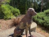 a statue of a dog that is sitting on a rock