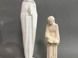 une statue représentant une femme tenant un enfant dans ses bras et une statue représentant une femme tenant un enfant dans ses bras