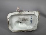 porcelain figurine of a toilet with a bird on top of it