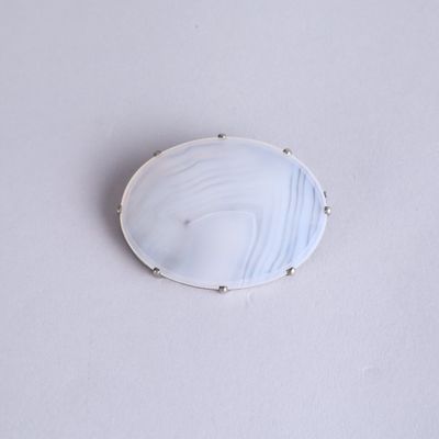 a close up of a white and blue broochle on a white surface