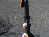 un scooter orange et blanc garé dans la rue