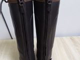 pair of brown leather boots with zippers on a wooden table