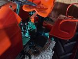 an orange tractor with a red bucket on the back
