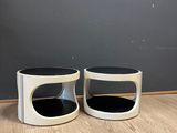 a pair of black and white side tables on a wooden floor