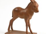 statue d'un âne posée sur un socle en bois, sur fond blanc
