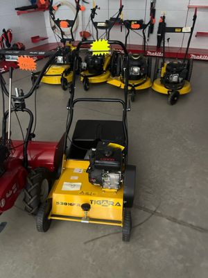 Plusieurs tondeuses à gazon sont alignées dans un garage