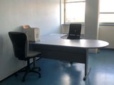 un bureau sur lequel se trouve un ordinateur, dans une pièce vide