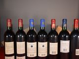 six bottles of red wine are lined up on a table