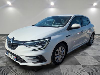 une voiture blanche garée dans une pièce au sol en damier