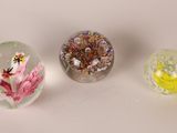 three glass vases with flowers inside of them on a table